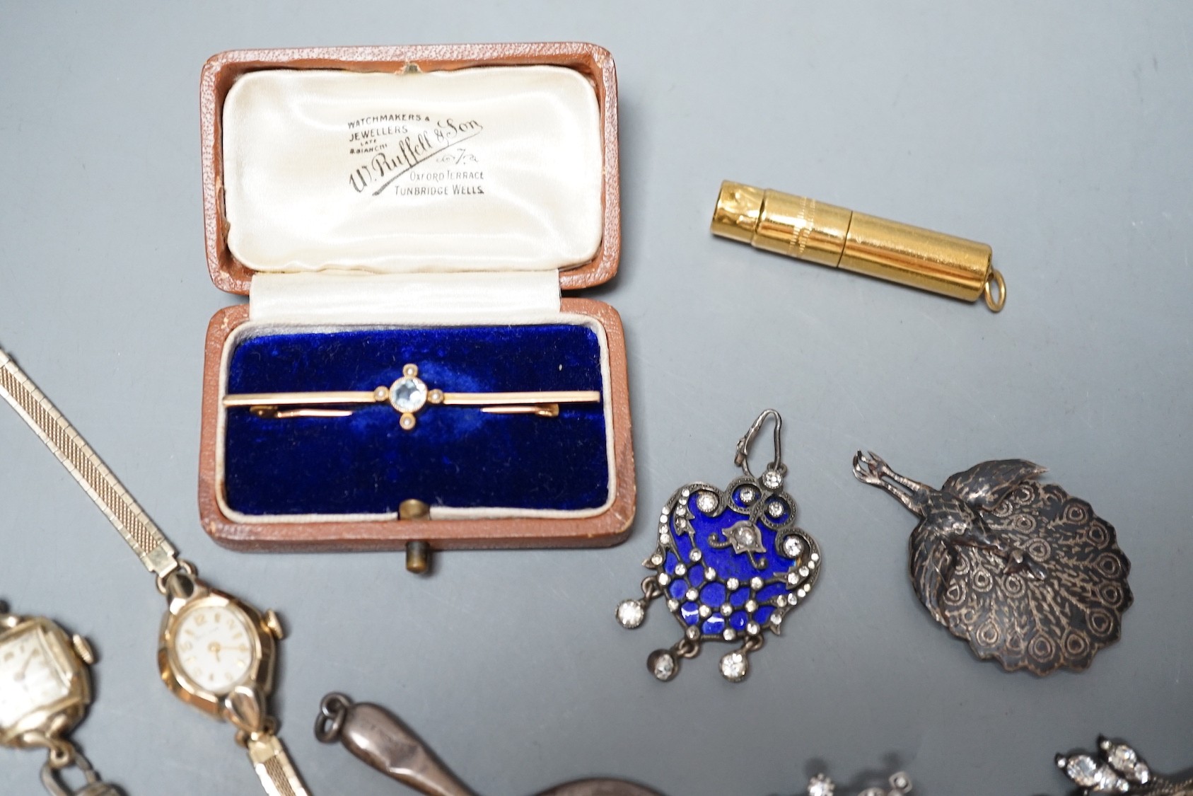 A cased Edwardian yellow metal, aquamarine and seed pearl set bar brooch, 55mm, sundry jewellery including costume, opal set scorpion brooch and enamel and paste set drop pendant and a wrist watch.